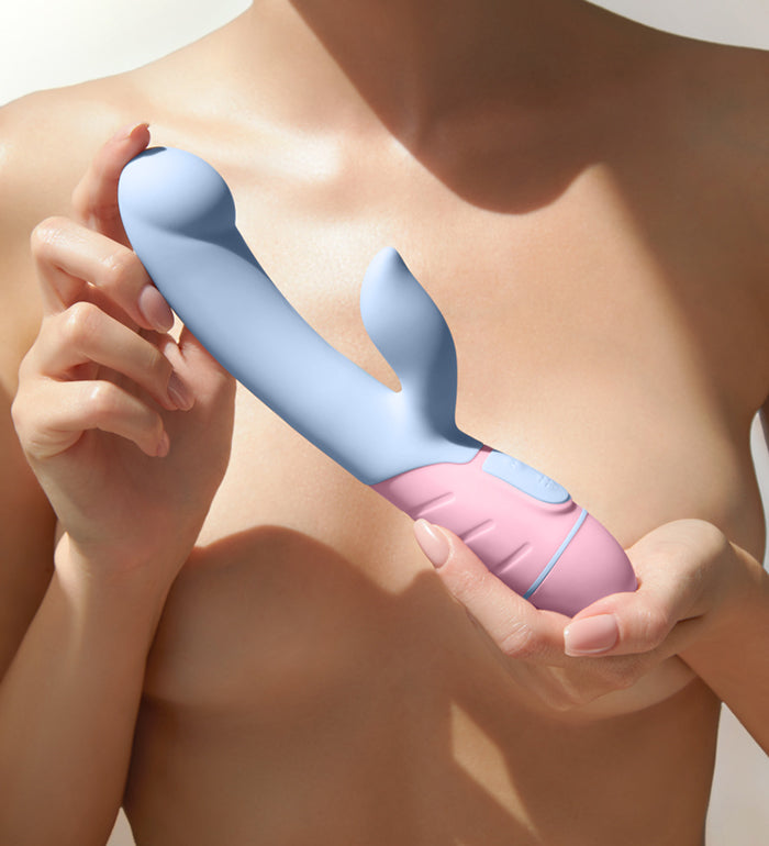 A shirtless person uses both of their hands to present the FemmeFunn FFIX Rabbit to the camera. The vibrator looks silky smooth to the touch. It looks like it's an average biological penis width at about 2 to 3 fingers in insertable width. The textured base looks easy to grasp. | Kinkly Shop