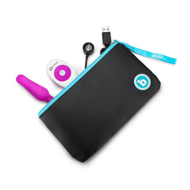 The b-Vibe Remote Novice Plug, remote, and charging cable peeking out from inside the opened zippered pouch that comes with the set. They all fit easily with lots of room to spare. | Kinkly Shop