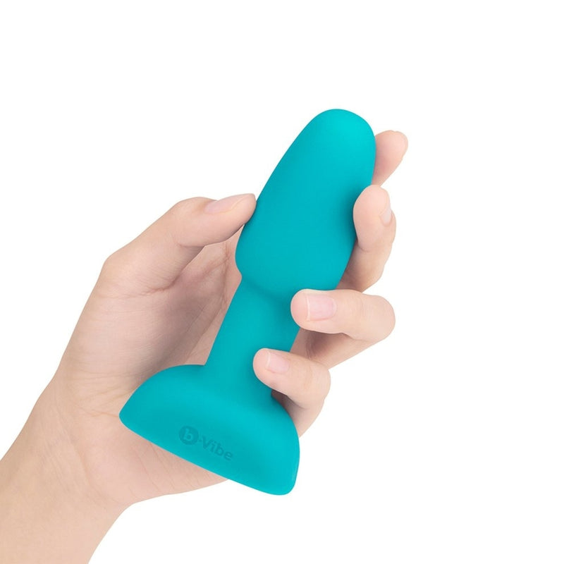 The b-Vibe Petite Rimming Plug in Teal in someone's hand. The plug looks relatively slender and short in the person's hand. It isn't as long as the person's palm to the tip of their fingers. It looks like it's smaller in width than 3 fingers at the widest point. | Kinkly Shop