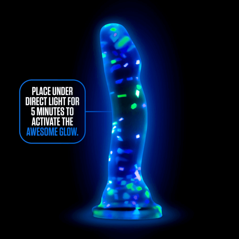 The Blush Neo Hanky Panky dildo shown up against a black background. The dildo is glowing with its glow-in-the-dark pigments. Text on the image reads: "Place under direct light for 5 minutes to activate the awesome glow." | Kinkly Shop