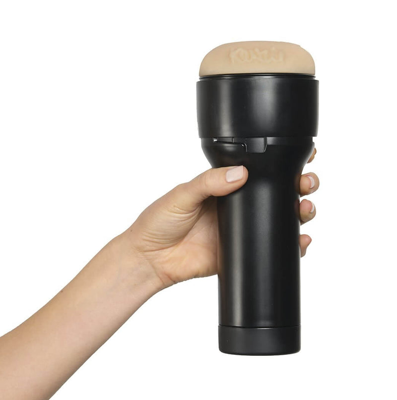 A hand holds the KIIROO FeelStars FeelKenzie Stroker. The hand wraps comfortably around the handle of the plastic case. | Kinkly Shop