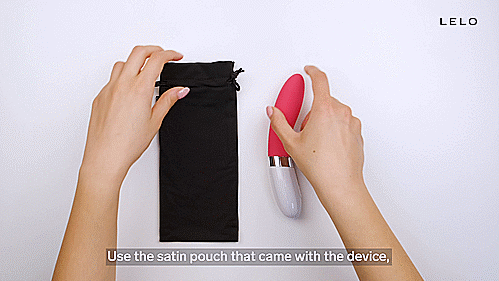 GIF showcases a person sliding the LELO LIV 2 into a black, drawstring bag. They then pull the strings of the bag to tighten the black bag around the LELO LIV 2's length. The vibrator fits smoothly into the bag. Text on the GIF reads: "Use the satin pouch that came with the device, and make sure to keep it in a dry and safe place without exposure to any heat or sunlight." | Kinkly Shop