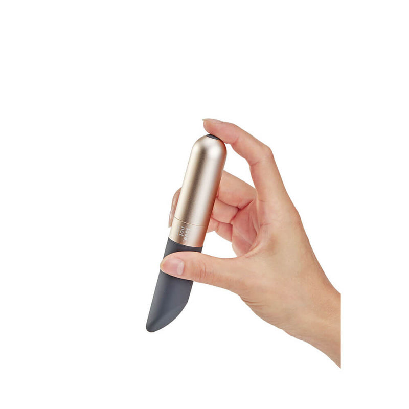 A person's hand holds the Love Not War Amore. The vibrator's shape naturally fits between the person's thumb and pointer finger with the angled, broad tip pointing towards the person's body while holding it like this. The tip could easily be laid flat on top of sensitive spots for pleasure while holding it naturally. | Kinkly Shop