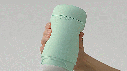 A hand is wrapped around the case of the Tenga Puffy. It squeezes the case, which responds to the squeeze, tightening the chamber inside. | Kinkly Shop