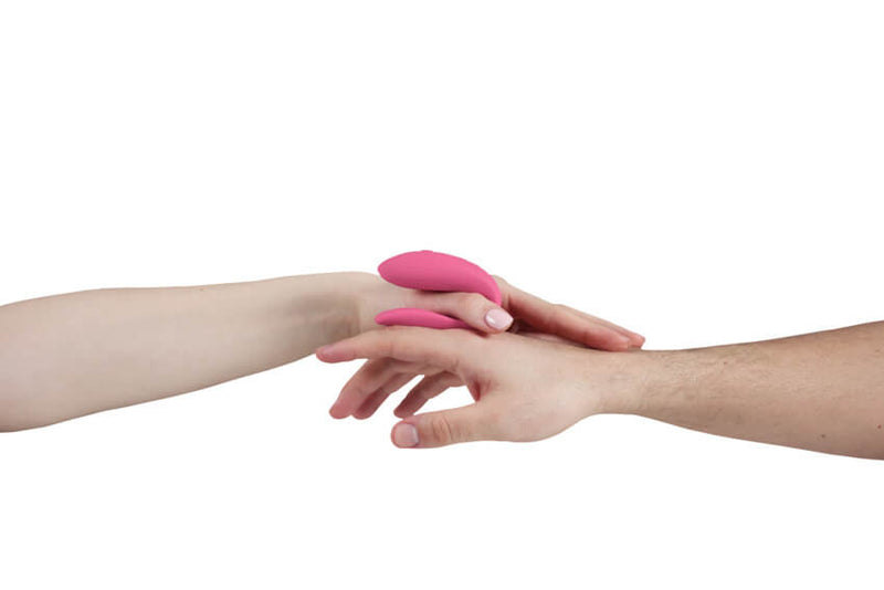 Two hands are embracing in front of a white background. The vibrator is about the size of the palm of a hand. | Kinkly Shop