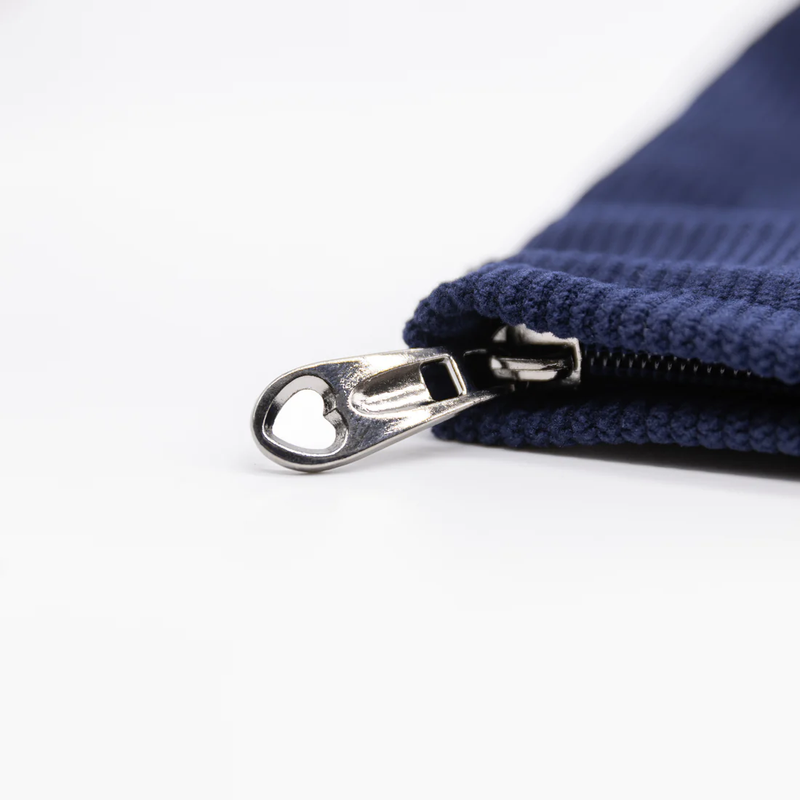Close-up of the zipper pull of the Emojibator Pleasure Pouch. It's a cute custom zipper with a little heart-shape out of the hole of the zipper. | Kinkly Shop