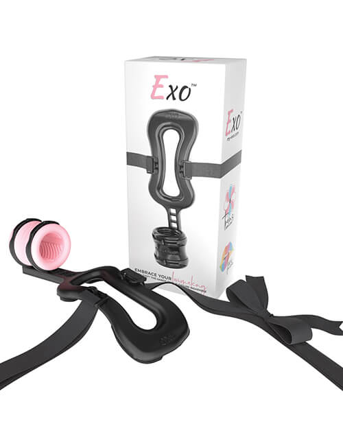 The pink EXO hands free penis sex toy sitting in front of the packaging for it. | Kinkly Shop