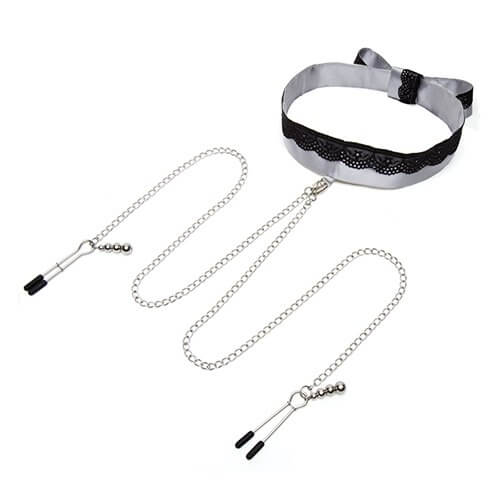 The "Play Nice" Satin Collar with Nipple Clamps laid out against a white background. The collar is fastened and propped up while the chains for the nipple clamps protrude from the collar itself. One nipple clamp is fastened shut and the other nipple clamp is open. | Kinkly SHop