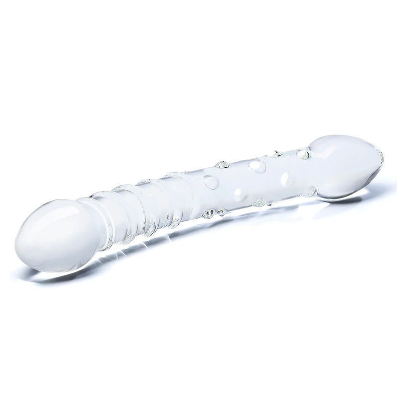 The Double Trouble Glass Dildo sits out on a plain white surface. From this angle, the pronounced, tapered tips of both ends are clear. | Kinkly Shop