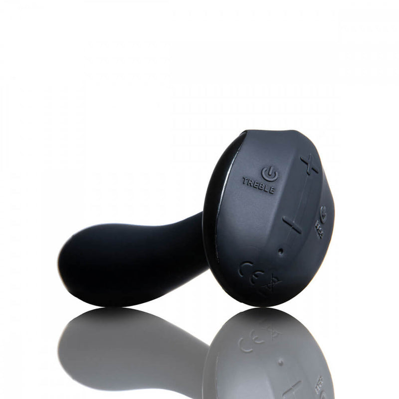 Sitting on a surface, the base of the Hot Octopuss PleX with Flex points towards the camera. This angle clearly shows the control buttons on the base of the anal vibrator. The plus and minus controls are located towards the top and bottom of the oval-shaped base, respectively. The Treble motor power button is on the left-hand side of the oval base while the Bass power button is on the right. | Kinkly Shop