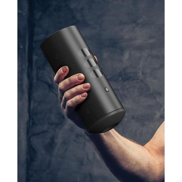 A hand holds the KIIROO Titan Interactive Vibrating Stroker in front of a charcoal background. They are able to comfortably one handed hold the stroker. The stroker is about 2.5 times as tall as their hand is wide. | Kinkly Shop