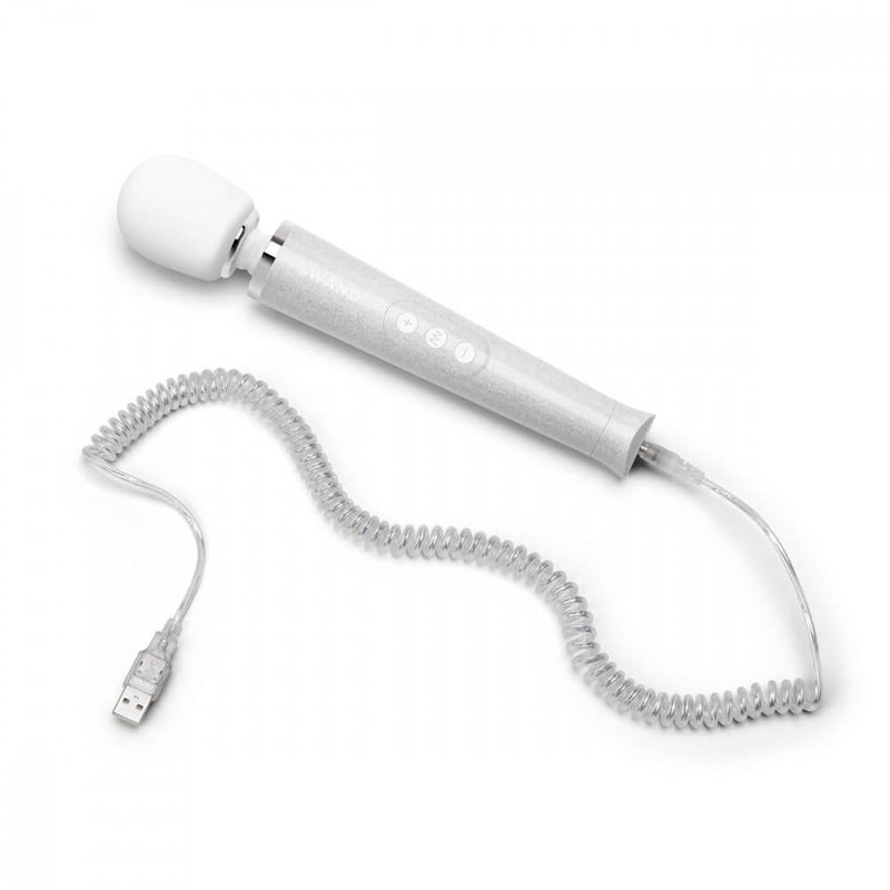 The Le Wand All that Glimmers Wand Massager laying out on a flat surface. Its color-matching charging cord is attached at the base of the wand. The cord includes spirals in a 90's style as well as a glitter coating that matches the wand massager. | Kinkly Shop