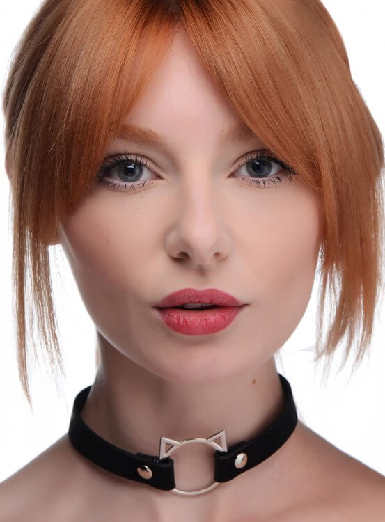 A red-headed person wears the Master Series Slim Kinky Kitty Ring Choker. It looks slim on their neck and doesn't take up much vertical space. | Kinkly Shop