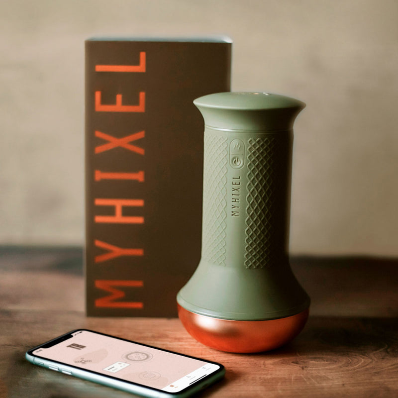 The MyHixel TR premature ejaculation sex toy shown next to the packaging with a cell phone laying flat next to it with the MyHixel Play app pulled up | Kinkly Shop