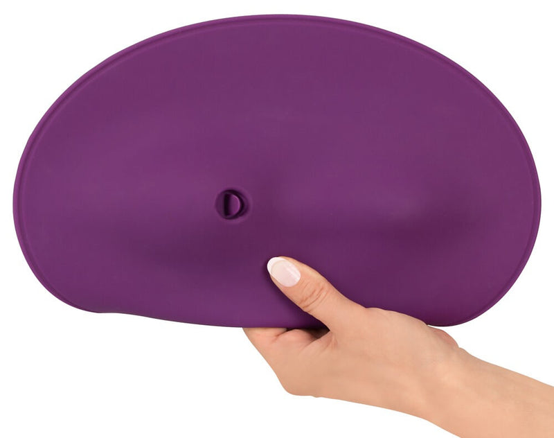 A hand grasps and bends the edges of the Orion VibePad 2. This showcases the very flexible, easily-tucked edges of the Orion VibePad 2 that helps protect the surface underneath the person using the vibrator. | Kinkly Shop