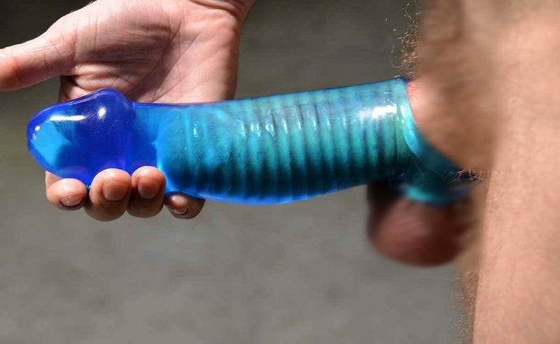 A person with an erection wears the Oxballs Muscle Cocksheath. The pubic hair and testicles are blurred. The close-up shot shows how tightly the ribbed gripping is around the person's shaft. The Oxballs Muscle Cocksheath also doesn't appear to add much girth, but it adds a lot of length. | Kinkly Shop