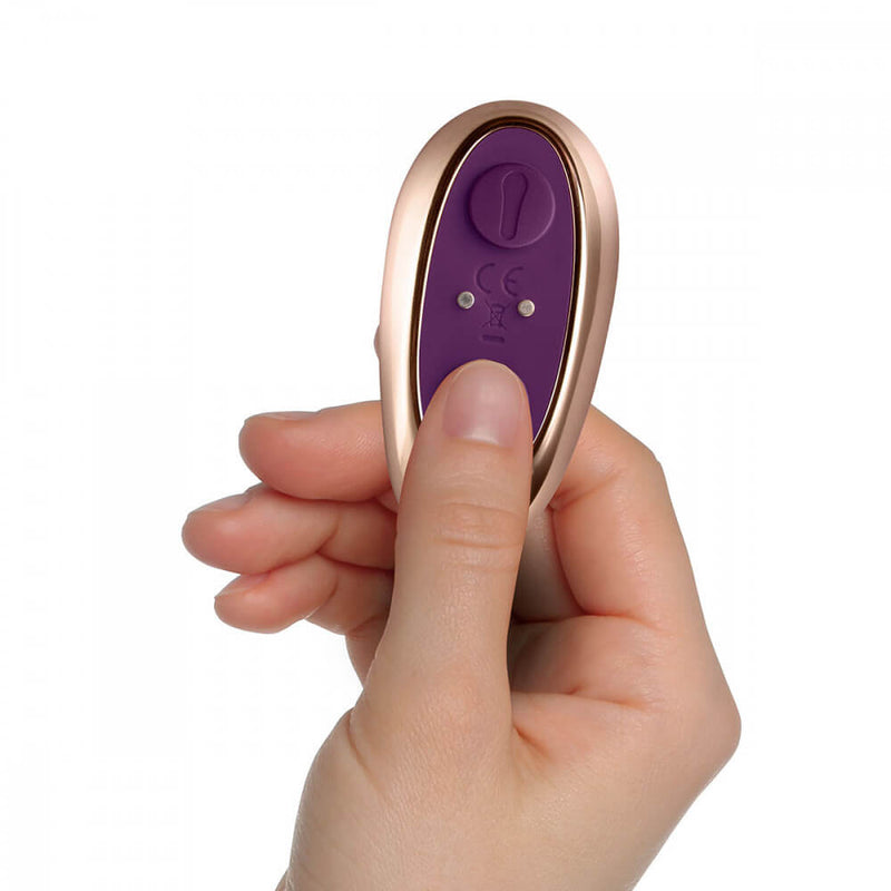 A hand holds onto the Rocks-Off Cocktail remote while the thumb presses on one of the buttons. The remote looks like it is slightly longer than the person's thumb. | Kinkly Shop