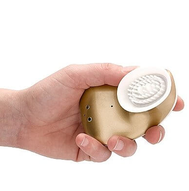 A hand holds the Shots Twitch Innovations. The vibrator is very short and stout, and it's slightly longer than the length of the person's fingers and about as wide as the person's palm. | Kinkly Shop