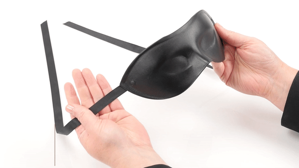 GIF shows a person handling the Blackout Mask. The text says "Soft satin ribbon", and the indentation shows how it has mold areas for the eyes. | Kinkly Shop
