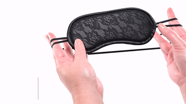 GIF of a person handling the Sportsheets Lace Blindfold. It shows how stretchy the head strap is. The text says "Double straps provide security and comfort." | Kinkly Shop