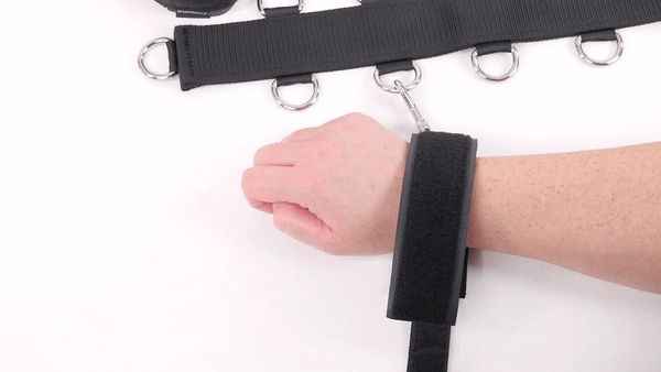 GIF shows a person wrapping the adjustable wrist cuffs around their wrist while the cuff is attached to the Neck strap of the Sportsheets Neck and Wrist Restraint | Kinkly Shop