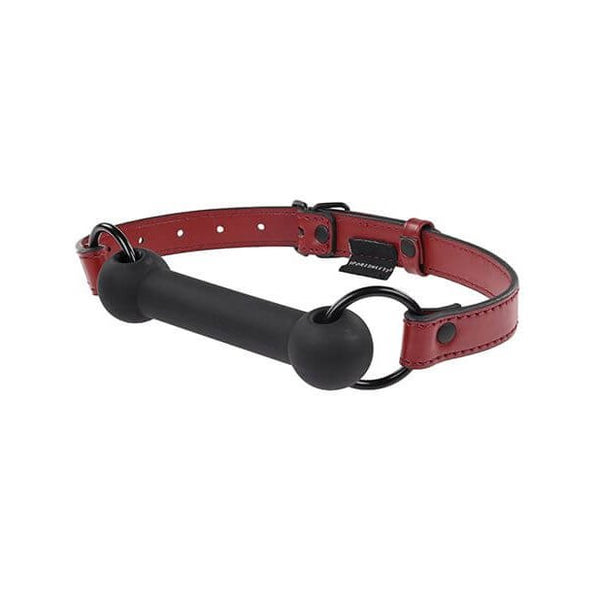 Sportsheets Saffron Silicone Bit Gag up against a white background. The silicone bit looks smooth and easy to bite down on. It's black in color in contrast to the dark red of the faux leather head strap. | Kinkly Shop