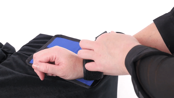 GIF shows a person fastening an adjustable bondage cuff around their wrist on a panel that is attached to the The Sportsheet Bondage Bedding (King). | Kinkly Shop