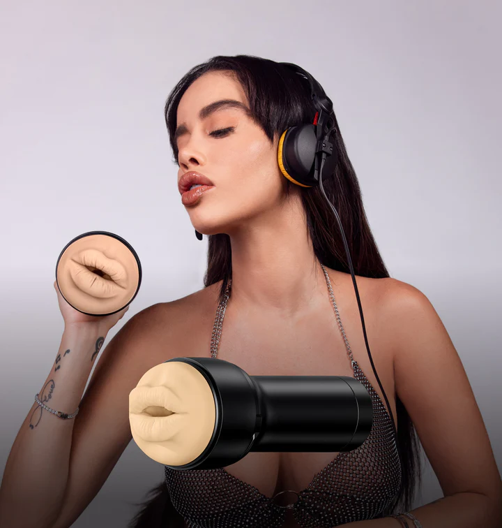 Victoria June wearing headphones, pouting with her lips towards the camera. She's also holding the KIIROO FeelStars FeelVictoria June Mouth stroker towards the camera, molded from her own lips. | Kinkly Shop
