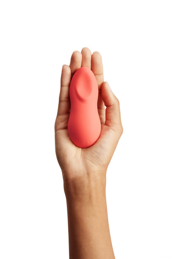 A person shows their outstretched palm. The We-Vibe Touch X is face-down in their palm with the unique, scoop-like area facing the camera. The control buttons are facing the person's palm. This angle showcases the oval-like "scoop" that is built into the Touch X for broad pressure when pressed flat against an area. | Kinkly Shop