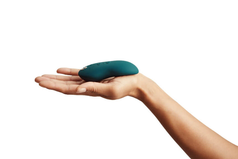 A person holds out their outstretched hand. The We-Vibe Touch X is resting in their palm. It takes up about the length of their palm but barely extends into the finger portion. | Kinkly Shop