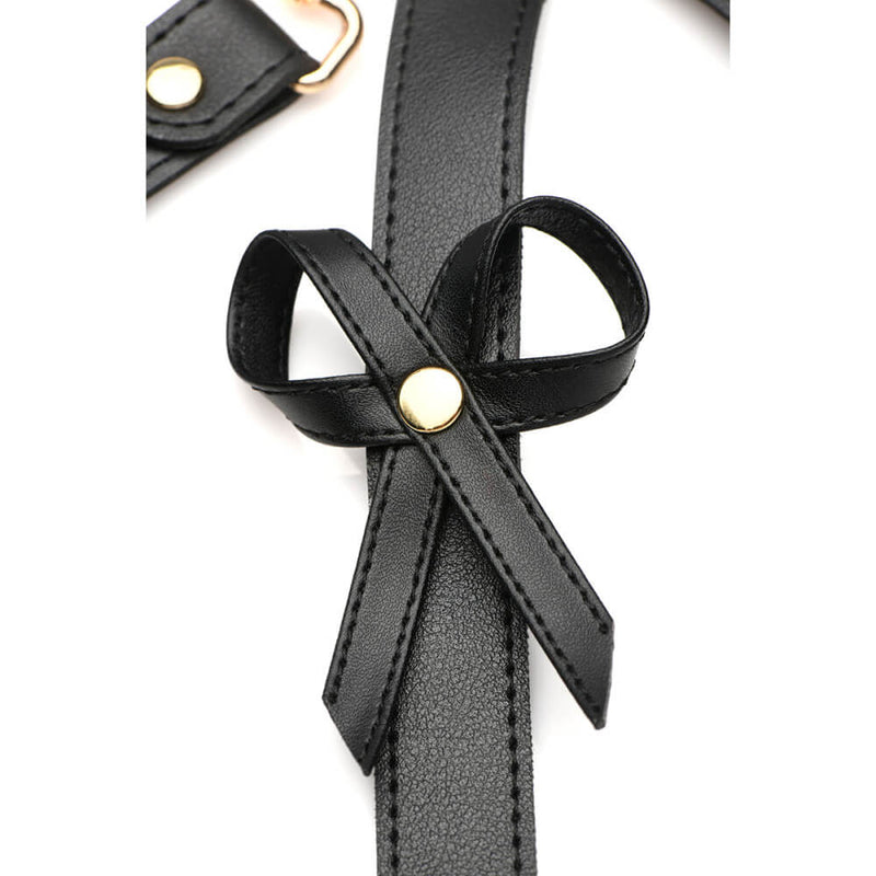 Close-up of one of the bows on the harness. It is a strand of leather that has been looped around and fastened onto the harness itself with a single rivet. | Kinkly Shop