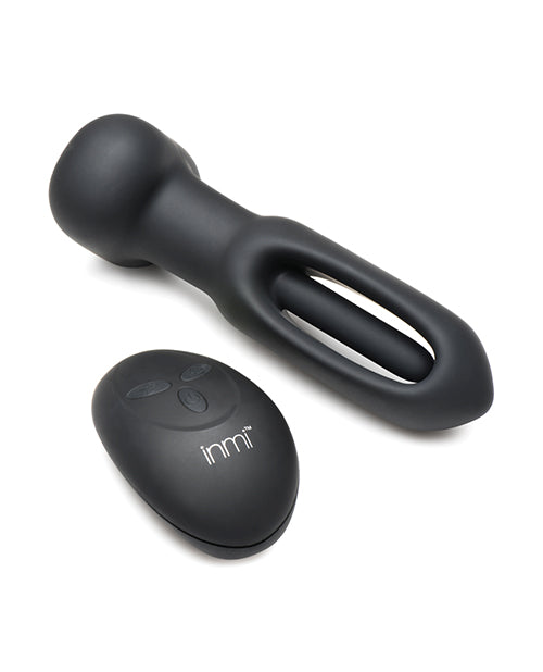 The Inmi Bum Flick butt plug next to the remote for it. There's a flicking "arm" inside of the hollow oval of the Inmi Bum Flick plug. | Kinkly Shop