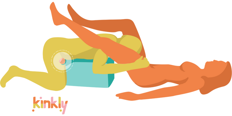 Illustration of two people using the Liberator On a Mission. One person is laying on top of the On a Mission, humping a Fleshlight inside of the sex toy mount. Their head is hanging off the top of the mount, between the legs of their partner who is laying on their back. They are using the penis stroker hands-free while providing oral sex totheir partner. | Kinkly Shop