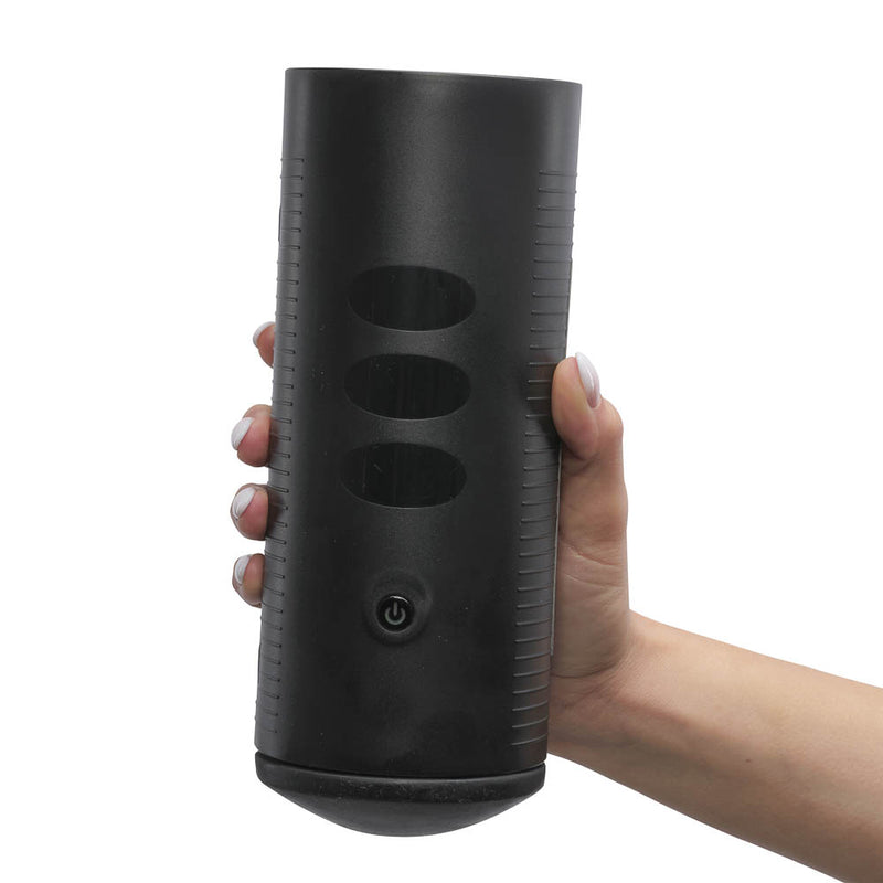 A hand holds the KIIROO Titan Interactive Vibrating Stroker. They are able to hold the KIIROO Titan Interactive Vibrating Stroker with just one hand. The power button and the touch panel are shown to the camera. There are plastic ridges along both sides of the case to make for easier handling of the KIIROO Titan Interactive Vibrating Stroker. | Kinkly Shop