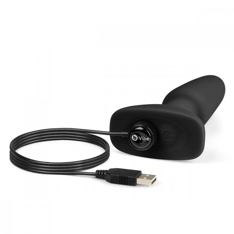 A close-up of the magnetic charging cable attached to the charging port at the base of the butt plug. The magnetic charging port charging area is right next to the power button on the base. | Kinkly Shop