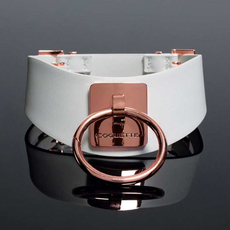 The Coquette Pleasure Collar in White against a black background. The Rose Gold hardware really stands out on the white collar with the white background. | Kinkly Shop