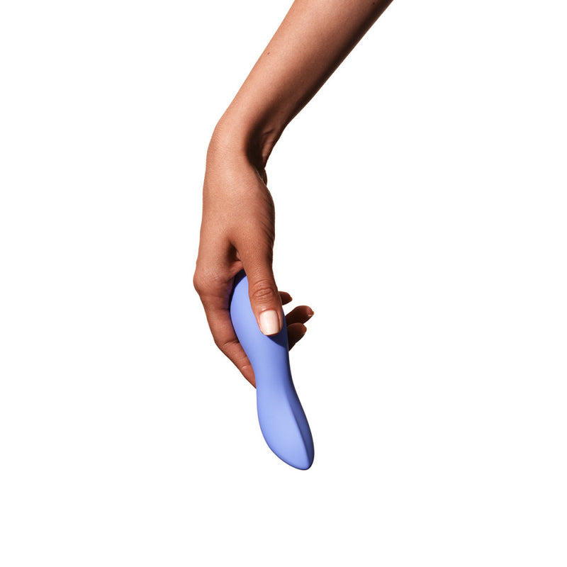 A hand holds the Dame Dip vibrator. It looks like it fits comfortably in their fingers, and it's about the exact same length as the person's entire hand. The pointed tip of the Dame Dip vibrator looks like it would fit easily into most crevices. | Kinkly Shop