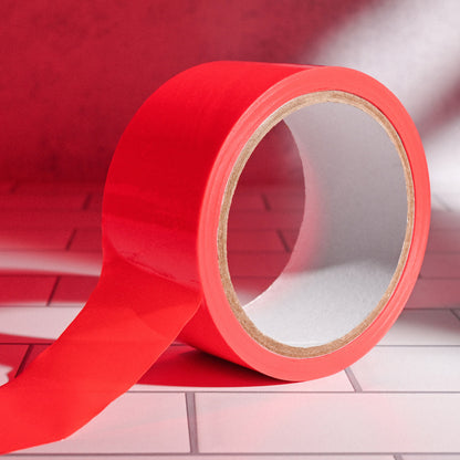 Evolved Bondage Tape in Red with a red light lighting the area | Kinkly Shop