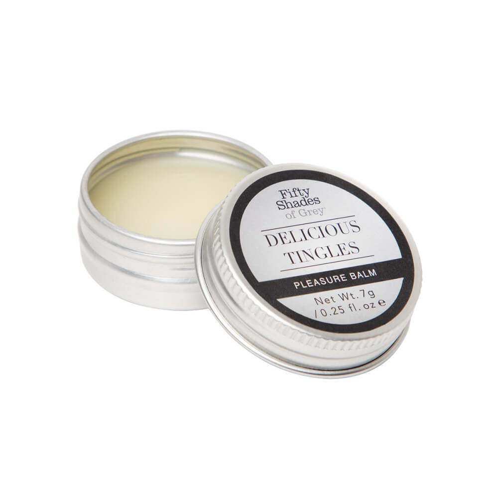 Close-up of the Delicious Tingles Pleasure Balm tin. It is a solid, wax-like balm that can be applied with fingers out of the tin. | Kinkly Shop