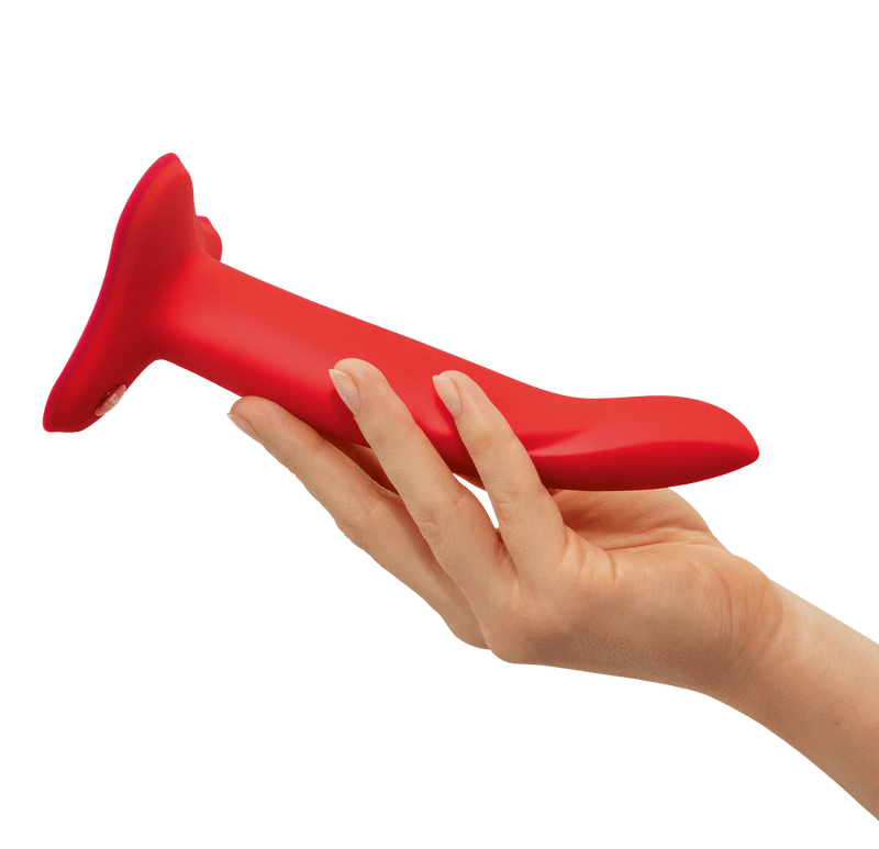 A hand holds the Medium Fun Factory Limba Flex dildo. It looks like it's about the thickness of three fingers. It's noticeably longer than the person's outstretched hand from palm to fingertip. | Kinkly Shop