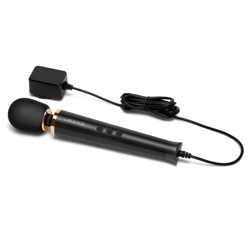 The Le Wand Petite Plug-In Massager in black with the power cord attached to the wand. It looks like a very long power cord with a box-style plug that plugs the massager into the wall. | Kinkly Shop