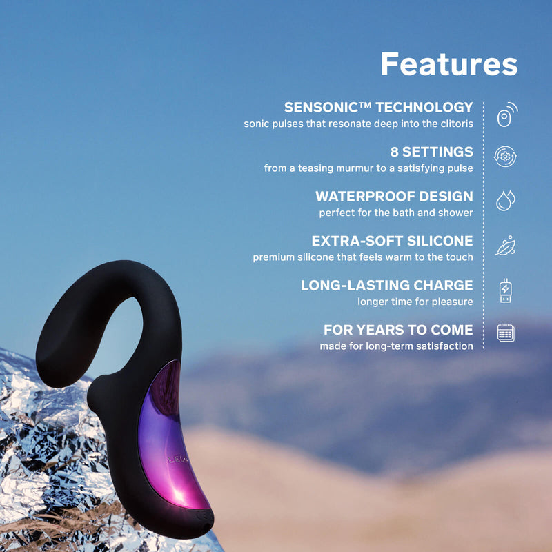 The LELO Enigma sits on a tin foil ledge. Text on the image reads: "Features. Sensonic technology. Sonic pulses that resonate deep into the clitoris. 8 settings from a teasing murmur to a satisfying pulse. Waterproof design perfect for the bath and shower. Extra-soft silicone that feels warm to the touch. Long-lasting charge. Longer time for pleasure. For years to come. Made for long-term satisfaction." | Kinkly Shop