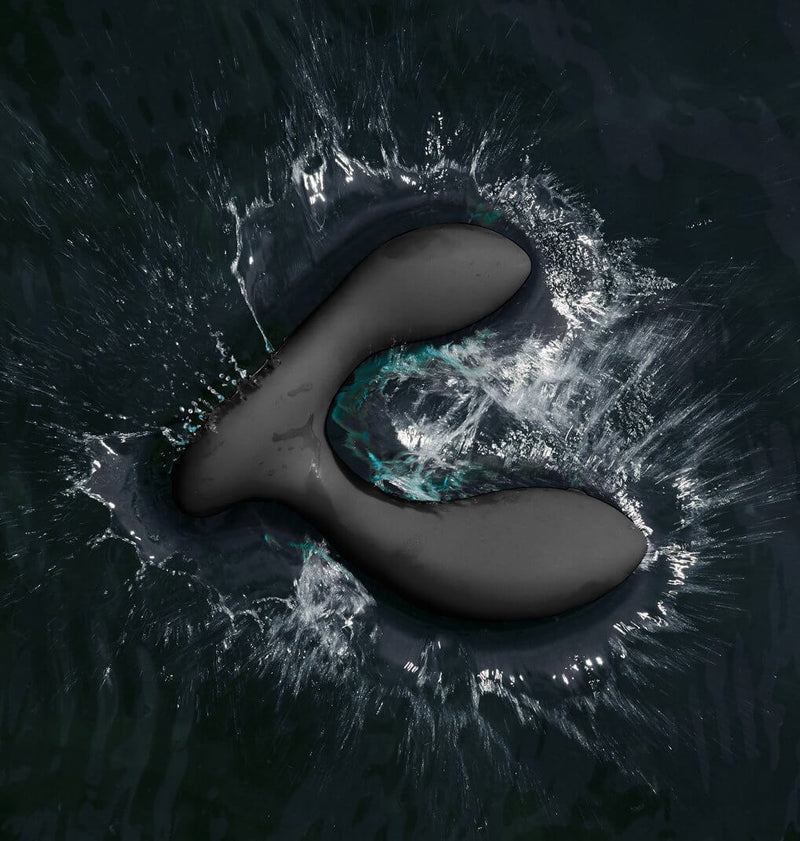 The LELO HUGO 2 in Black without Remote dropped into a pond of water, splashing around the toy. This showcases the vibrator's waterproof capabilities. | Kinkly Shop