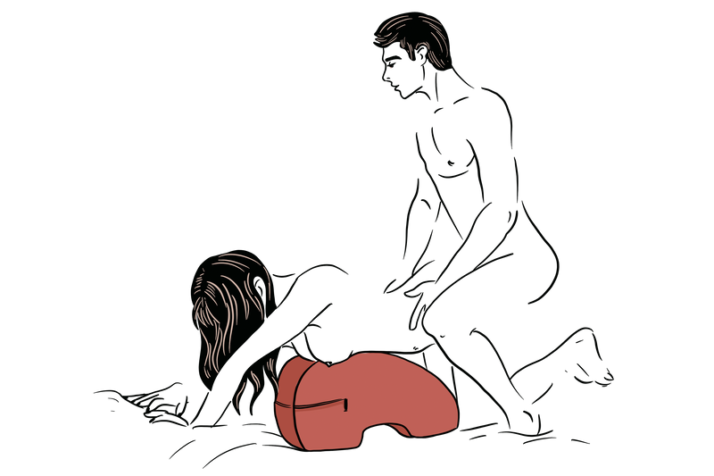Illustration of two people using the Liberator Pulse. The Pulse is flipped upside down with the flat edge pressing down on the bed. A receiving partner is leaning overtop of the Pulse, using the Pulse to support their chest in a on-all-fours position. A penetrating partner is kneeling behind them, penetrating from behind. | Kinkly Shop