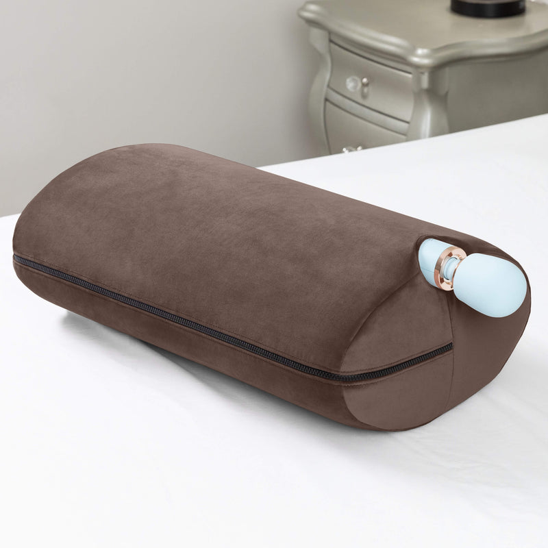 The Liberator Wing in Brown resting on top of a bed. A light blue, full-sized wand massager is tucked into the Wing. The Wing holds it in position with a snug fit. | Kinkly Shop
