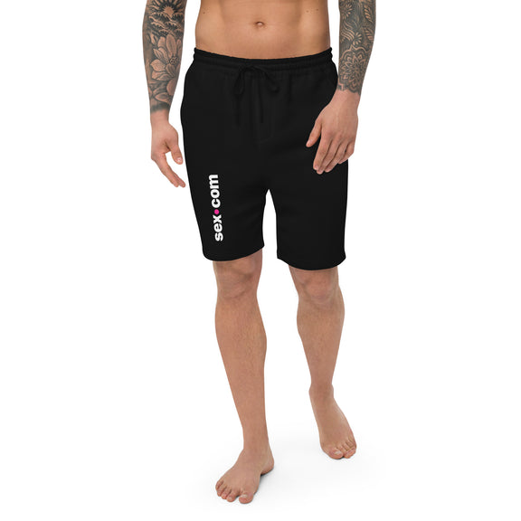 A person wears the Sex.com Men's Fleece Shorts in Black. The Sex.com logo runs vertically down the right leg of the sweatpants. | Kinkly Shop