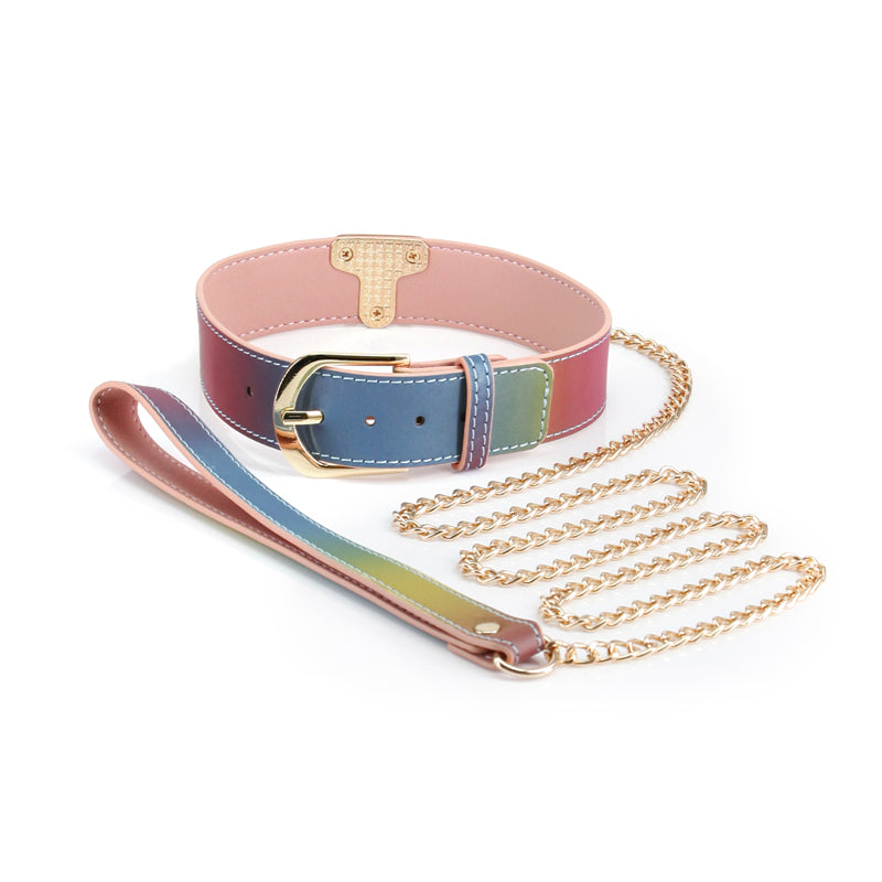 The NS Novelties Spectra Rainbow Collar and Leash up against a white background. The interior faux leather color is a light pink while the external color is a rainbow ombre. All of the hardware is a shiny gold. | Kinkly Shop