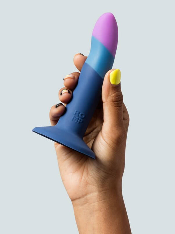 A hand holds the ROMP Piccolo. The dildo looks about the length of the person's flattened hand from base of palm to tip of finger, and only about as thick as 2.5 fingers. | Kinkly Shop