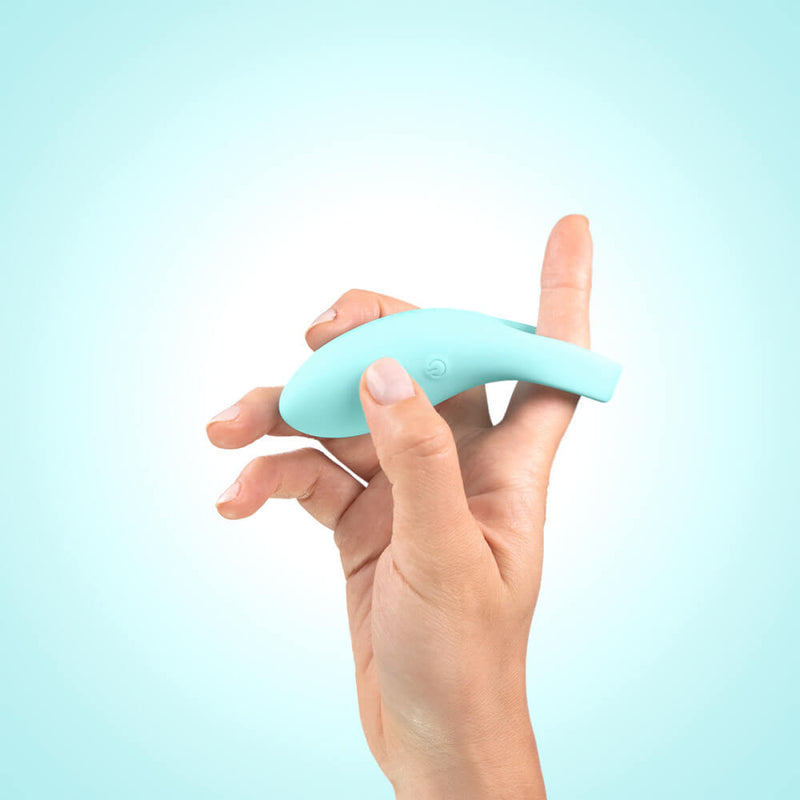 A hand holds the SELF + Jimmyjane Vibrating C-Ring with a finger slid through the center ring of the SELF + Jimmyjane Vibrating C-Ring. The vibrator extends a fair way away from the ring itself to best reach your erogenous zones. | Kinkly Shop