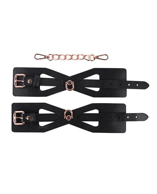 A top-down, lay flat image showing everything that is included with the Sportsheets Brat Cuffs. The two cuffs come with a matching chain that can clip both of the cuffs together for instant handcuffs. | Kinkly Shop